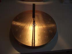 Spot-On Sundial in brass, showing noontime@line of light"