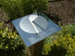 sundial, stainless, on a wooden post